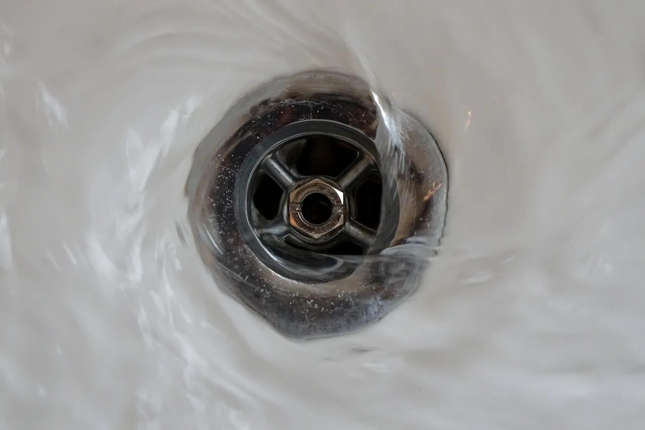 Sink drain close-up with running water
