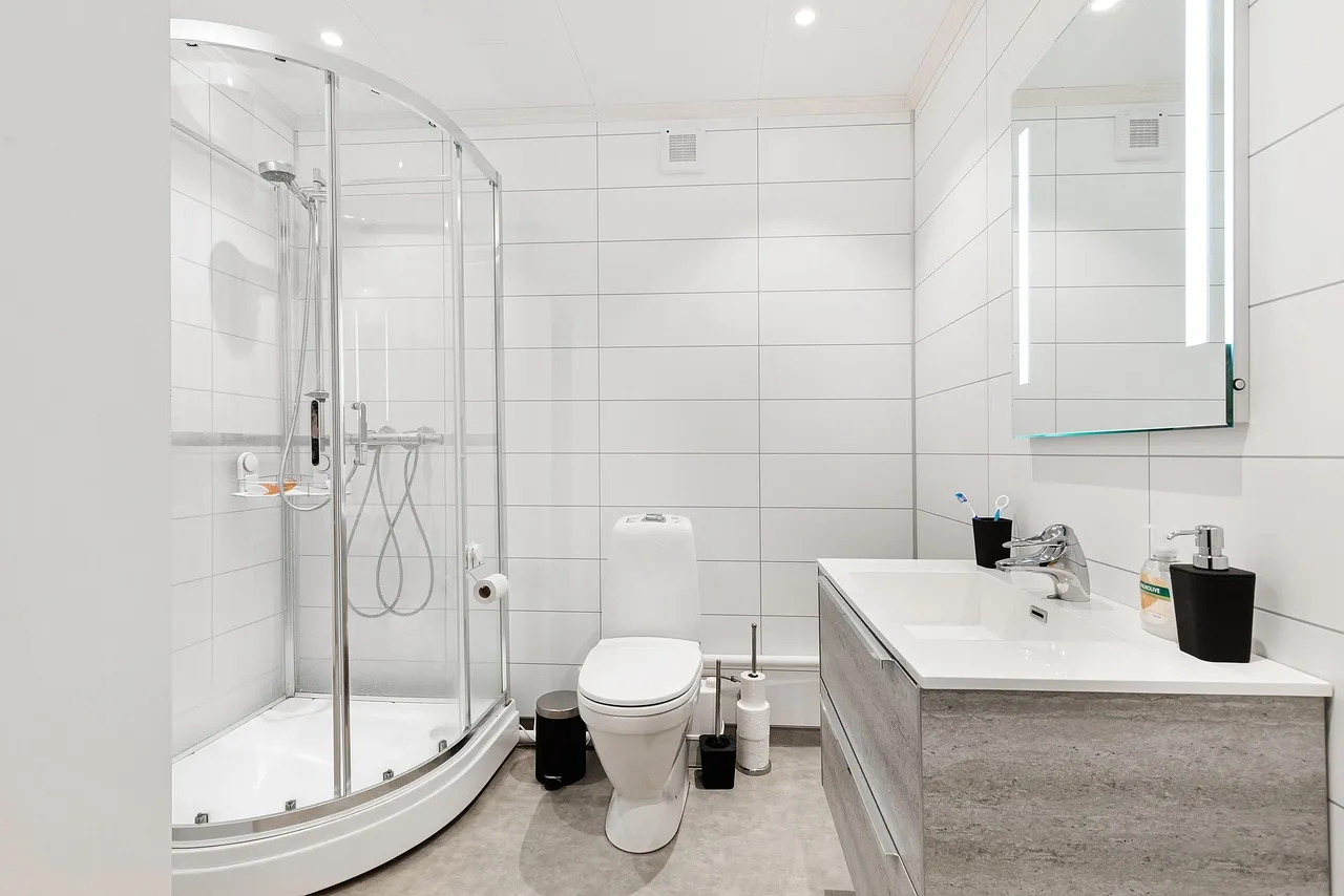 Residential bathroom with toilet, shower and vanity